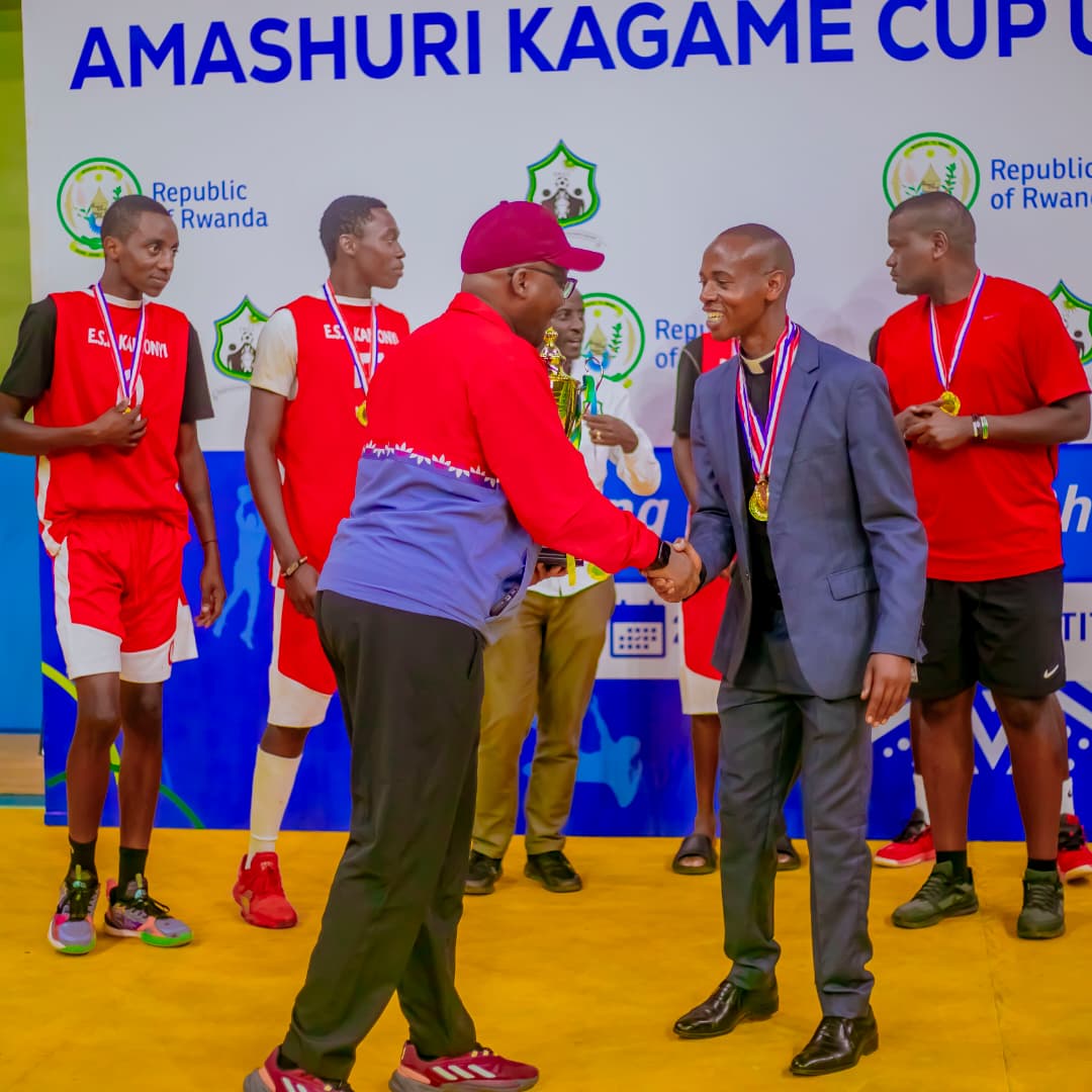 Umuyobozi Mukuru wa REB, Dr. Mbarushimana Nelson, ashimira Padiri Majyambere Jean d'Amour uyobora ESB Kamonyi yegukanye ibikombe bine